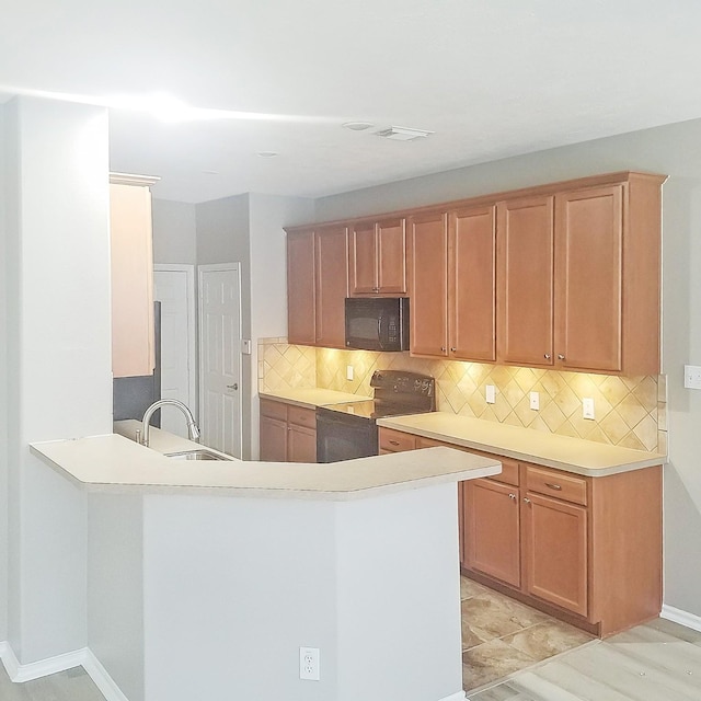 kitchen featuring backsplash, kitchen peninsula, sink, and black appliances