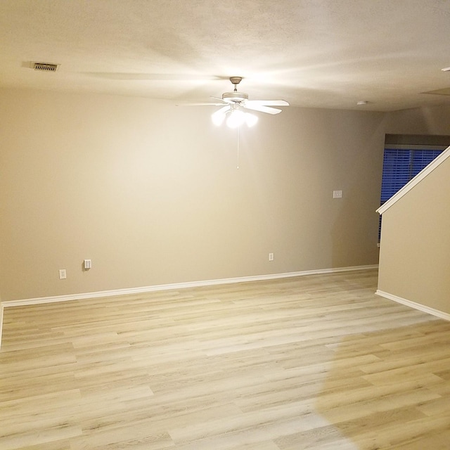 spare room with light wood-type flooring and ceiling fan