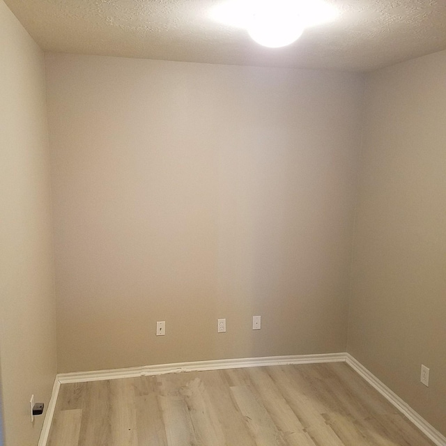 spare room with hardwood / wood-style floors and a textured ceiling