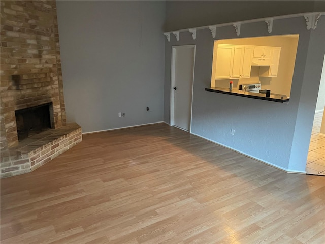 unfurnished living room with a fireplace and light wood-type flooring