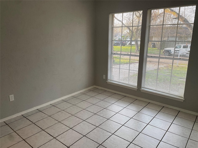 spare room with a wealth of natural light and light tile patterned floors