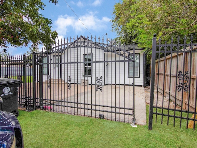 view of gate with a yard and a garage