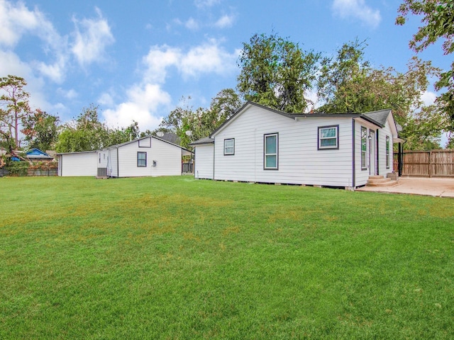 rear view of property with a lawn and a patio area