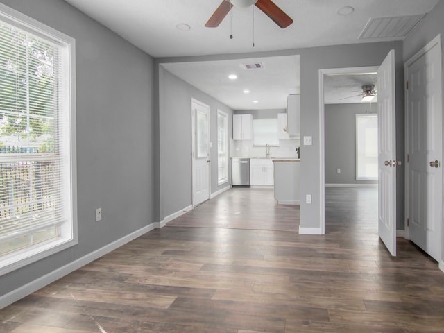 unfurnished living room featuring ceiling fan, sink, and dark hardwood / wood-style floors