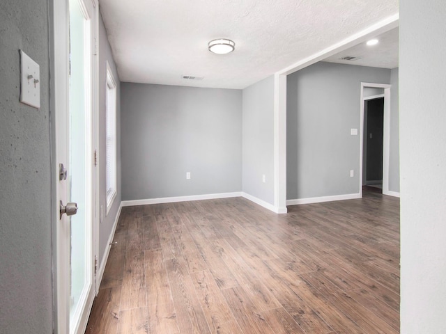 unfurnished room with hardwood / wood-style floors and a textured ceiling