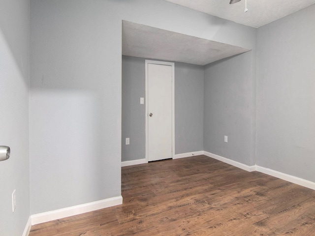 empty room featuring dark wood-type flooring and a textured ceiling