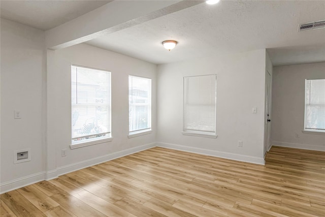 unfurnished room featuring a textured ceiling and light wood-type flooring