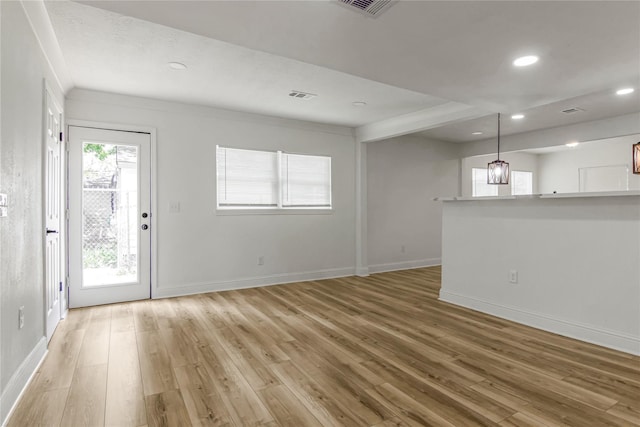 unfurnished living room with wood-type flooring and ornamental molding