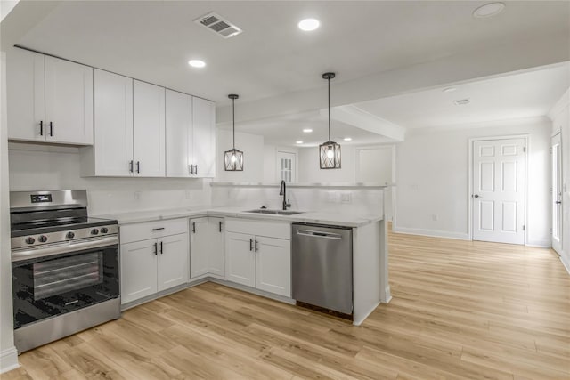 kitchen with sink, stainless steel appliances, pendant lighting, light hardwood / wood-style floors, and white cabinets