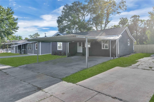 ranch-style house featuring a carport and a front lawn