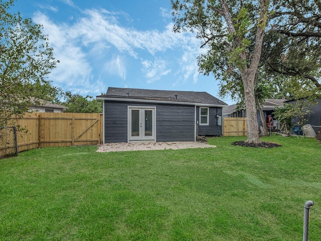 rear view of house with a lawn and french doors