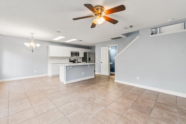 kitchen featuring sink, light tile patterned floors, an island with sink, white cabinets, and appliances with stainless steel finishes