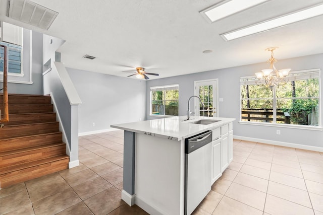 kitchen featuring dishwasher, sink, an island with sink, light tile patterned flooring, and ceiling fan with notable chandelier