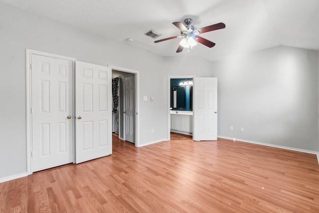 unfurnished bedroom with light wood-type flooring, ceiling fan, lofted ceiling, and connected bathroom