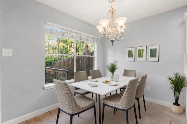 dining space featuring light tile patterned flooring and an inviting chandelier