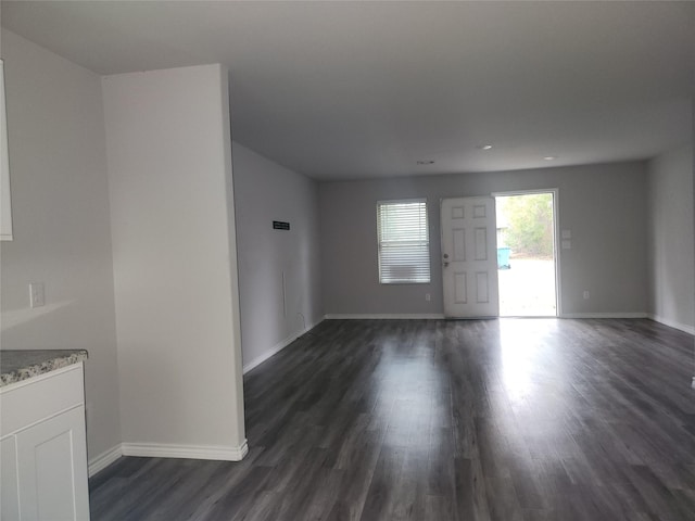 unfurnished living room with dark wood-type flooring