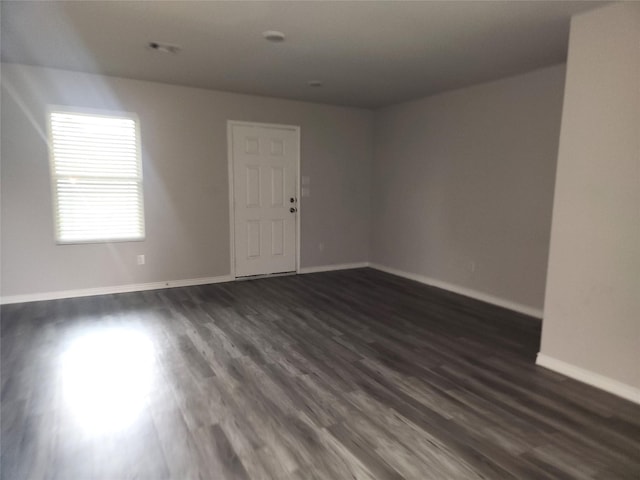 unfurnished room featuring dark wood-type flooring