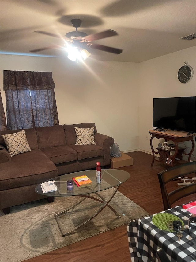 living room featuring ceiling fan and dark wood-type flooring