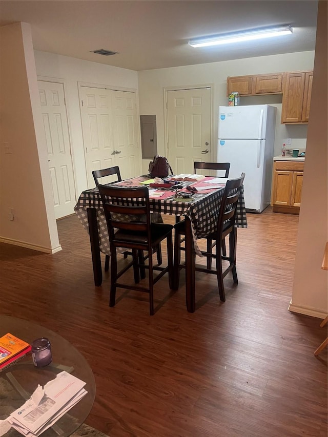 dining room with electric panel and dark wood-type flooring