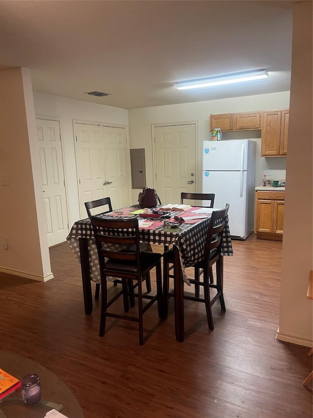 dining room with dark hardwood / wood-style floors and electric panel