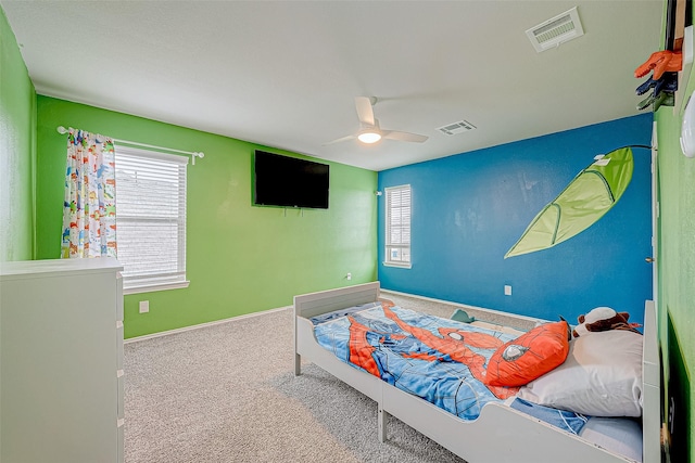 carpeted bedroom with ceiling fan and multiple windows