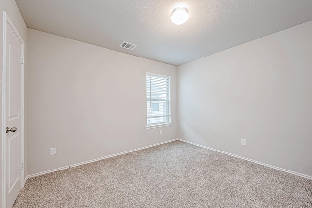 carpeted spare room featuring a textured ceiling