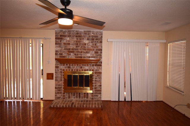 unfurnished living room featuring a fireplace, dark hardwood / wood-style floors, and ceiling fan