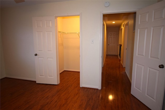 unfurnished bedroom with dark hardwood / wood-style floors, a spacious closet, and a closet