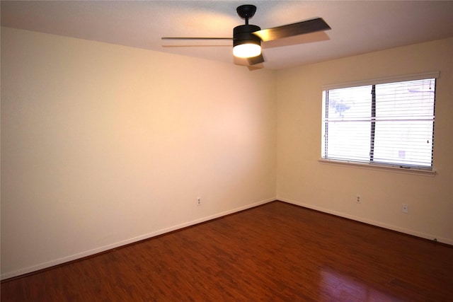 empty room with dark hardwood / wood-style floors and ceiling fan