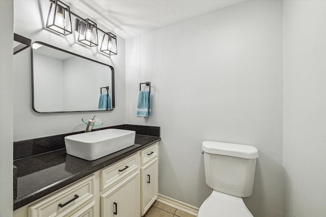 bathroom featuring vanity, a textured ceiling, toilet, and tile patterned flooring