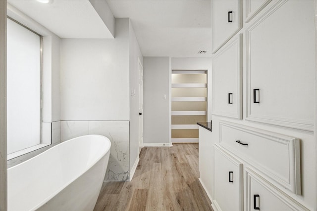 bathroom featuring hardwood / wood-style flooring and a washtub