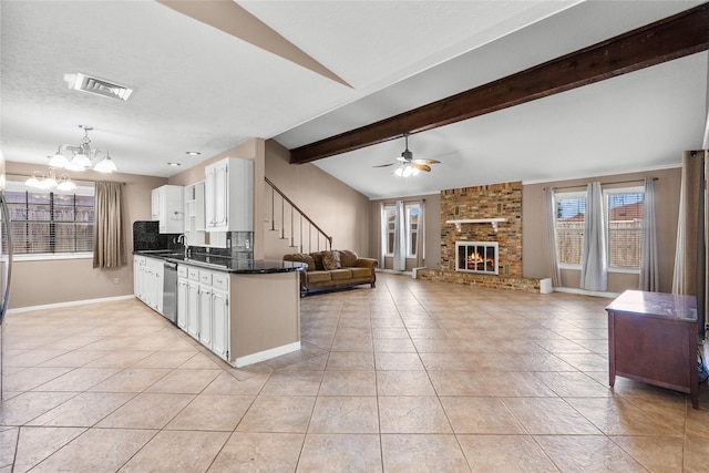 kitchen with white cabinetry, dishwasher, sink, a fireplace, and ceiling fan with notable chandelier