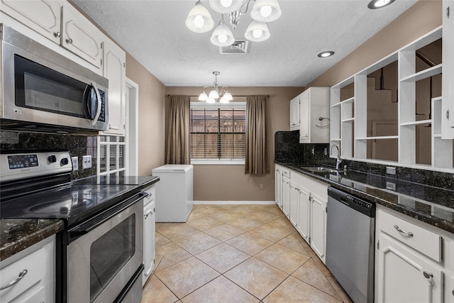 kitchen with backsplash, decorative light fixtures, appliances with stainless steel finishes, a notable chandelier, and white cabinetry