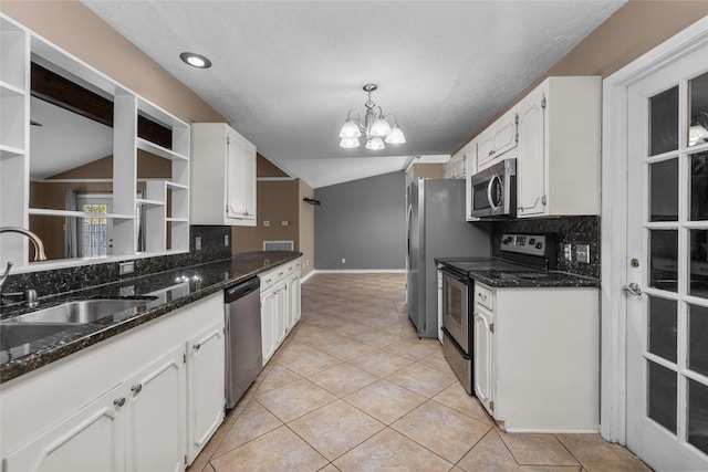 kitchen with white cabinets, sink, stainless steel appliances, and vaulted ceiling