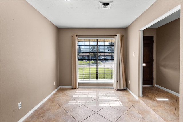 unfurnished room with plenty of natural light and light tile patterned floors