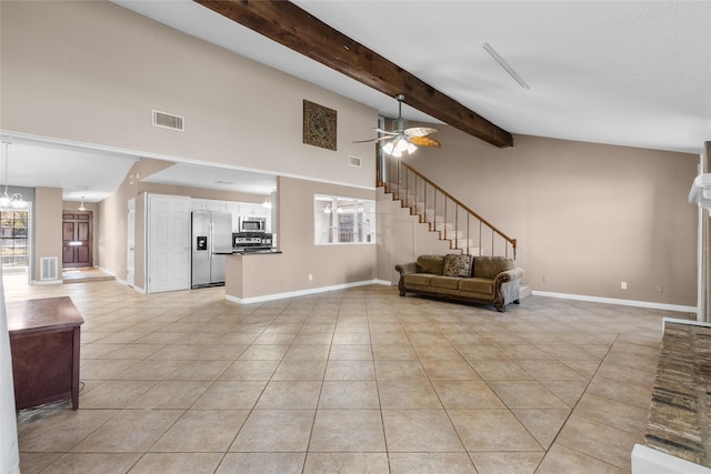 unfurnished living room with ceiling fan, beam ceiling, light tile patterned floors, and a towering ceiling