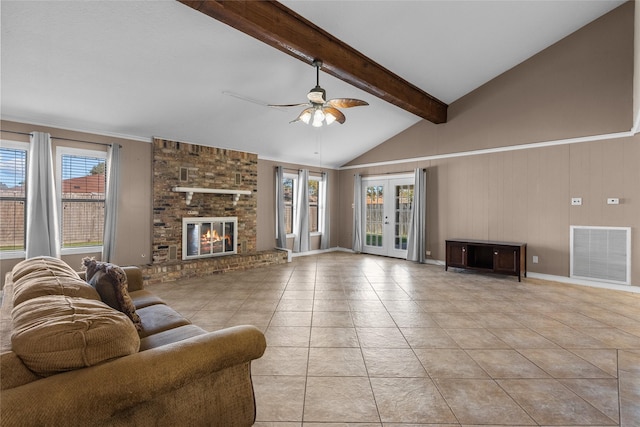 tiled living room with a fireplace, ceiling fan, french doors, and a healthy amount of sunlight