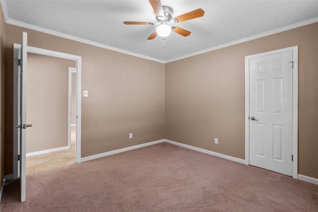 carpeted spare room featuring ceiling fan and crown molding