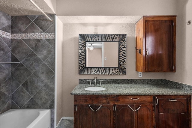 bathroom featuring vanity, ceiling fan, and tiled shower / bath combo