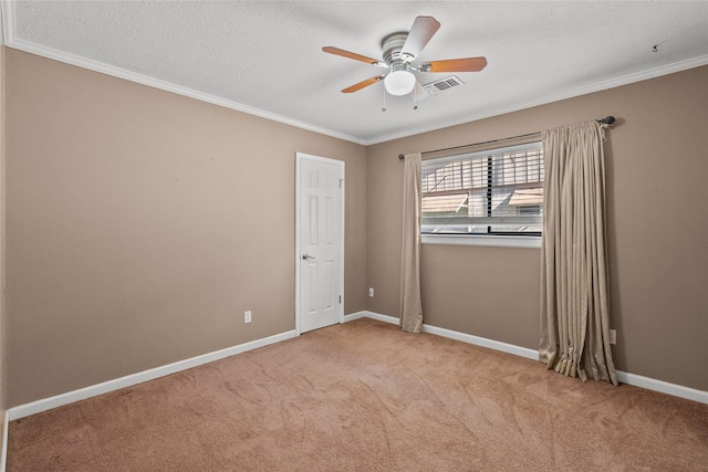 unfurnished room featuring light carpet, a textured ceiling, ceiling fan, and ornamental molding