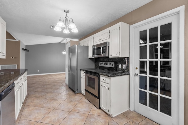 kitchen featuring white cabinetry, light tile patterned flooring, decorative light fixtures, and appliances with stainless steel finishes