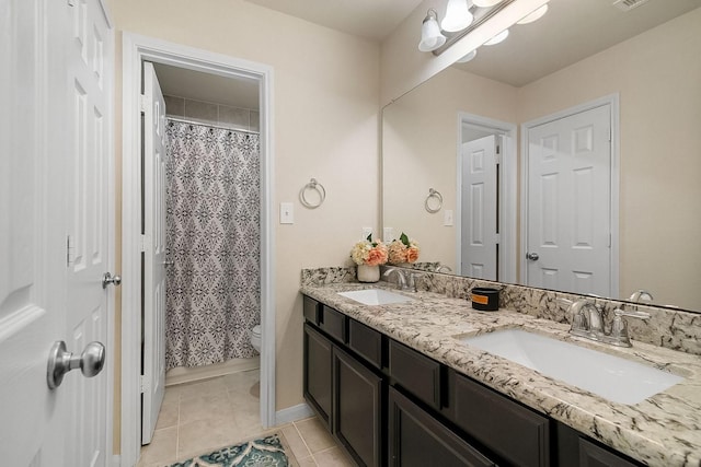 bathroom with tile patterned flooring, vanity, toilet, and walk in shower