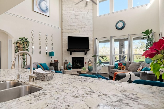 living room featuring a stone fireplace and sink