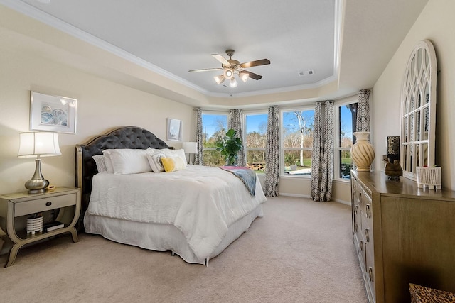 carpeted bedroom with a raised ceiling, ceiling fan, and crown molding