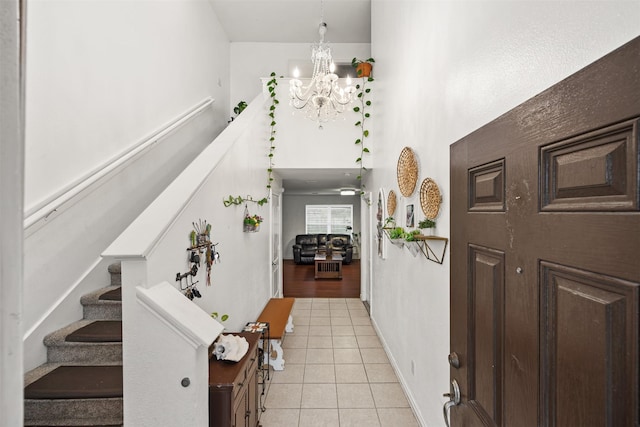 tiled foyer featuring an inviting chandelier