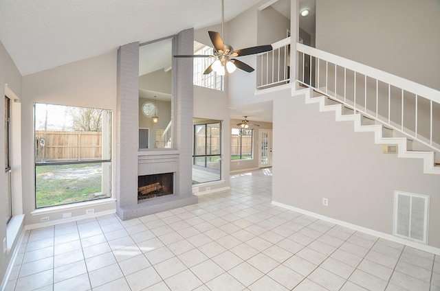 unfurnished living room featuring a fireplace, high vaulted ceiling, ceiling fan, and light tile patterned flooring