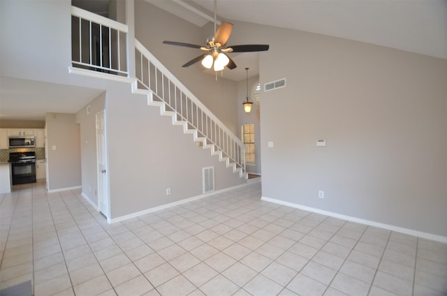 unfurnished room with ceiling fan, light tile patterned floors, and high vaulted ceiling