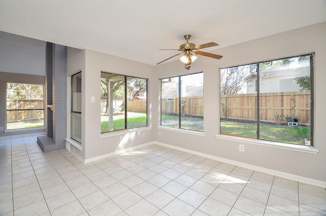 unfurnished sunroom featuring a wealth of natural light and ceiling fan