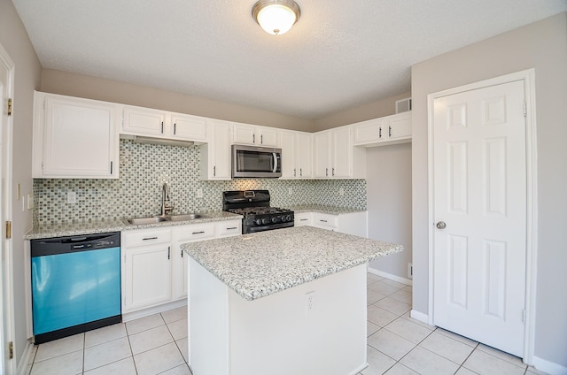 kitchen featuring stainless steel appliances, a kitchen island, sink, light tile patterned floors, and white cabinetry