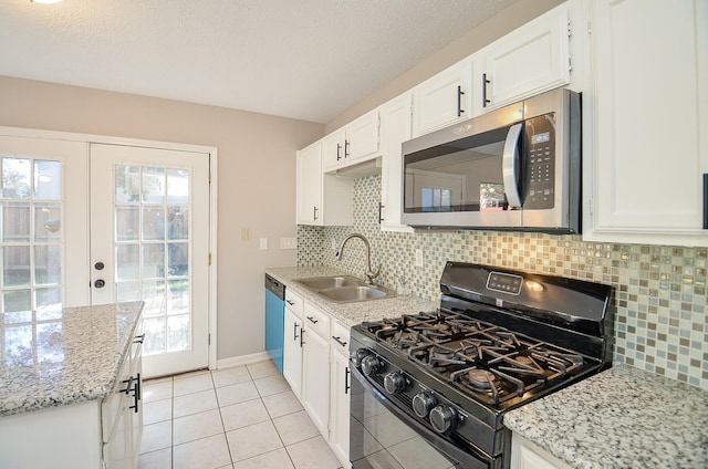 kitchen with light stone countertops, appliances with stainless steel finishes, white cabinetry, and sink